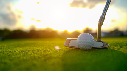 Golf clubs and balls on a green lawn in a beautiful golf course with morning sunshine.