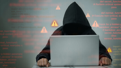 Hacker in Dark Hoodie with Cybersecurity Alert Warnings
