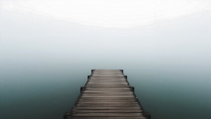 Obraz premium Wooden Pier Stretching into a Foggy Lake Landscape offering Tranquility and Solitude for Contemplation and Reflection