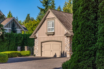 Garage door in luxury house with trees and nice landscape in Summer in Vancouver, Canada, North America. Day time on July 2025.