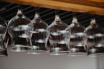 Glasses hanging upside down above the bar counter. Clean transparent glasses