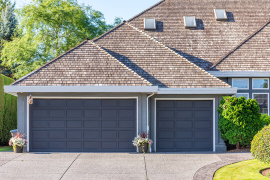 Garage door in luxury house with trees and nice landscape in Summer in Vancouver, Canada, North America. Day time on July 2025.