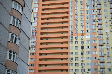 Two contrasting apartment buildings showcase different architectural styles and colors in a vibrant...