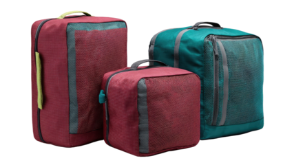 Three travel bags in varying shades of maroon, teal, and burgundy.  Each bag features a transparent panel, handles, and a zippered closure.  They are a compact and organized set