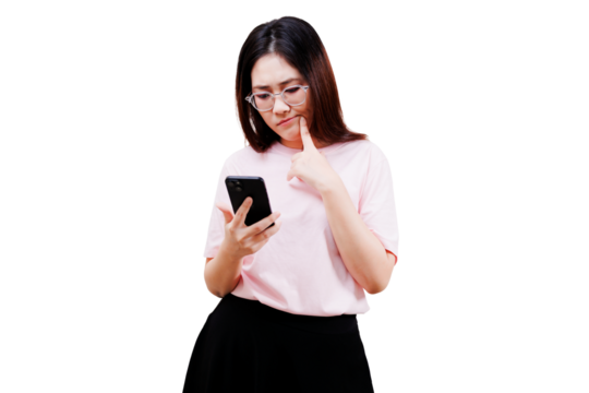 Asian young beautiful woman in a pink shirt examines a smartphone while pondering, displaying curiosity and concentration.