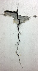 A large crack bisects a white wall, revealing a gray interior