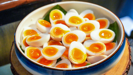 Delicious boiled eggs with fresh orange fruit on a plate and a bowl of Thai dessert 