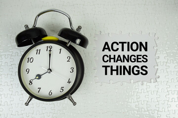 Action Changes Things text with alarm clock on white background