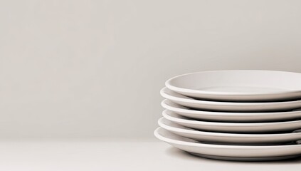 Obraz premium Stacked white plates against a light beige background