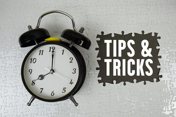 Tips And Tricks text with alarm clock on gray background