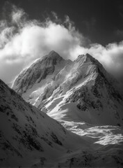 Obraz premium Snowy mountain peak, dramatic light. Towering, icy summit, illuminated by a sunlit cloud formation. Sharp angled slopes and glacial patterns