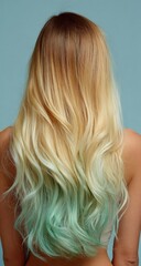 Naklejka premium A woman's long, wavy, blonde hair with a mint green ombre