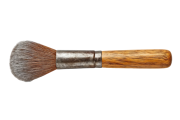 Close-up of a makeup brush with a light brown wooden handle and a metal ferrule. The brush head is a light brownish-gray, slightly tapered, and densely packed with bristles