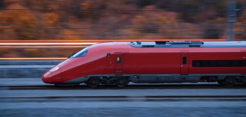 Red aerodynamic bullet train speeds along tracks creating light streaks. Futuristic locomotive efficient intercity mobility, modern infrastructure. High-speed travel, connection, business commute.