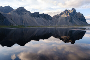 Majestic Vestrahorn mountain reflects in tranquil waters of Stokksnes in Iceland scenic landscape