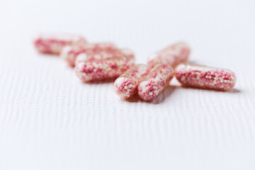 Vitamin B12 (also known as cobalamin) capsules on bright paper background. Soft focus. Close up. Copy space.