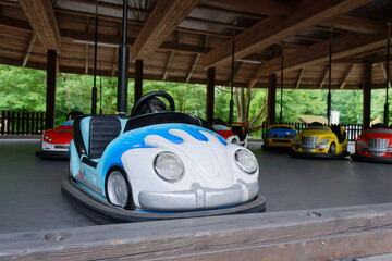 Colorful bumper cars parked inside outdoor amusement zone