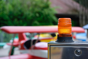 Orange warning lamp on metal box near children helicopter rides