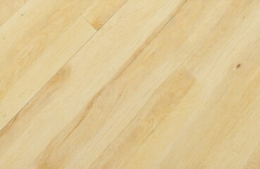 Fototapeta premium Close-up of yellow laminate flooring with natural wood grain texture. Light oak planks showcase seamless pattern, ideal for interior design, renovation, and home decor projects.