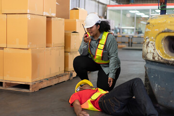 Female worker calling for help via walkie-talkie after a male colleague's accident in a warehouse. Represents workplace safety, emergency response, and industrial hazards