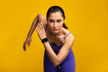 Healthy Lifestyle. Front portrait of confident young lady in blue sportswear running towards camera. Determined female jogging and sprinting isolated over orange studio background wall