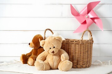Two adorable brown teddy bears sitting on a soft surface next to a wicker basket holding a pink pinwheel. This charming still life evokes feelings of childhood innocence.