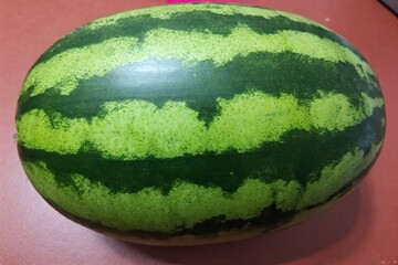 Whole and slice of ripe watermelon, heap of watermelon slices as background