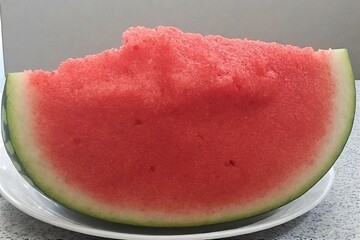 Whole and slice of ripe watermelon, heap of watermelon slices as background