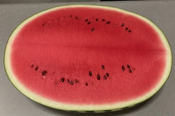 Whole and slice of ripe watermelon, heap of watermelon slices as background