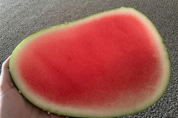 Whole and slice of ripe watermelon, heap of watermelon slices as background
