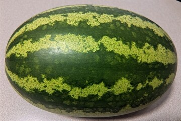 Whole and slice of ripe watermelon, heap of watermelon slices as background