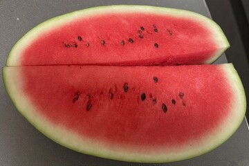Whole and slice of ripe watermelon, heap of watermelon slices as background