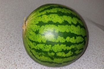 Whole and slice of ripe watermelon, heap of watermelon slices as background