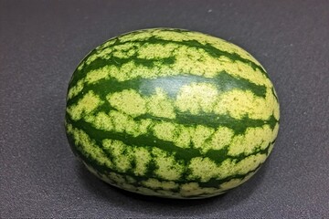 Whole and slice of ripe watermelon, heap of watermelon slices as background