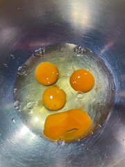Ei Dotter und Eiweiß in einer Schüssel aus Edelstahl sehen aus wie ein Gesicht