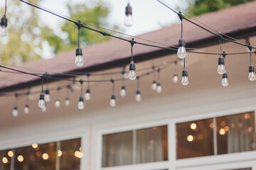 String lights illuminate a backyard gathering at sunset, creating a warm and inviting atmosphere...