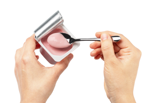 Woman holding pink yogurt in plastic cup and eating with spoon on transparent background