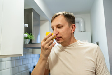 Man sniffing the lemon. Anosmia or smell blindness, loss of the ability to smell, one of the possible symptoms of covid-19, infectious disease caused by corona virus. Relax therapee