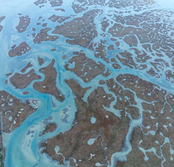 Shapes and textures in the Ria Formosa in the Algarve. Aerial view from a drone. Protected as a Coastal Natural Park and Ramsar Site in the Algarve region. Portugal, Europe.