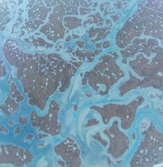 Shapes and textures in the Ria Formosa in the Algarve. Aerial view from a drone. Protected as a Coastal Natural Park and Ramsar Site in the Algarve region. Portugal, Europe.