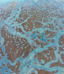 Shapes and textures in the Ria Formosa in the Algarve. Aerial view from a drone. Protected as a Coastal Natural Park and Ramsar Site in the Algarve region. Portugal, Europe.