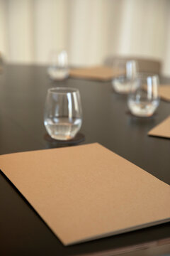 Boardroom meeting setup with documents and glasses