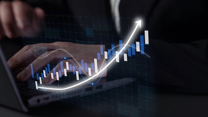 A business professional is focused on financial data analysis, with a laptop displaying a graph...