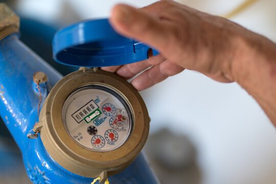 Senior man examining a water meter in rural setting