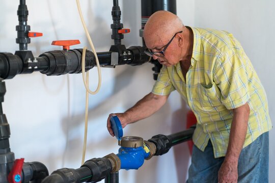 Senior man inspecting water system in rural setting