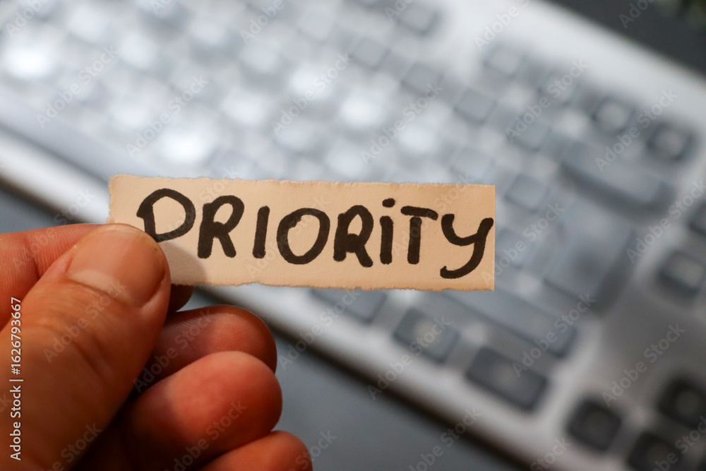 Poster a person holding a paper with the word priority in bold letters. the background features a blurred k