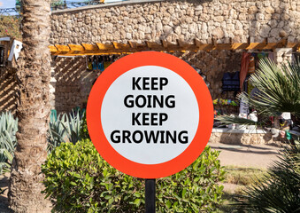 Keep going and growing symbol. Concept words phrase Keep going keep growing on beautiful road sign....