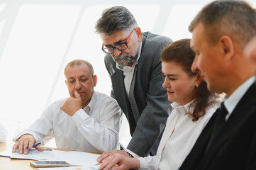 Business team analyzing data in meeting with senior leader