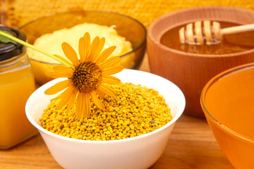 Vibrant display of natural ingredients with pollen, honey, and flower on a wooden table