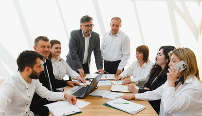 Business team analyzing data and discussing strategy in meeting